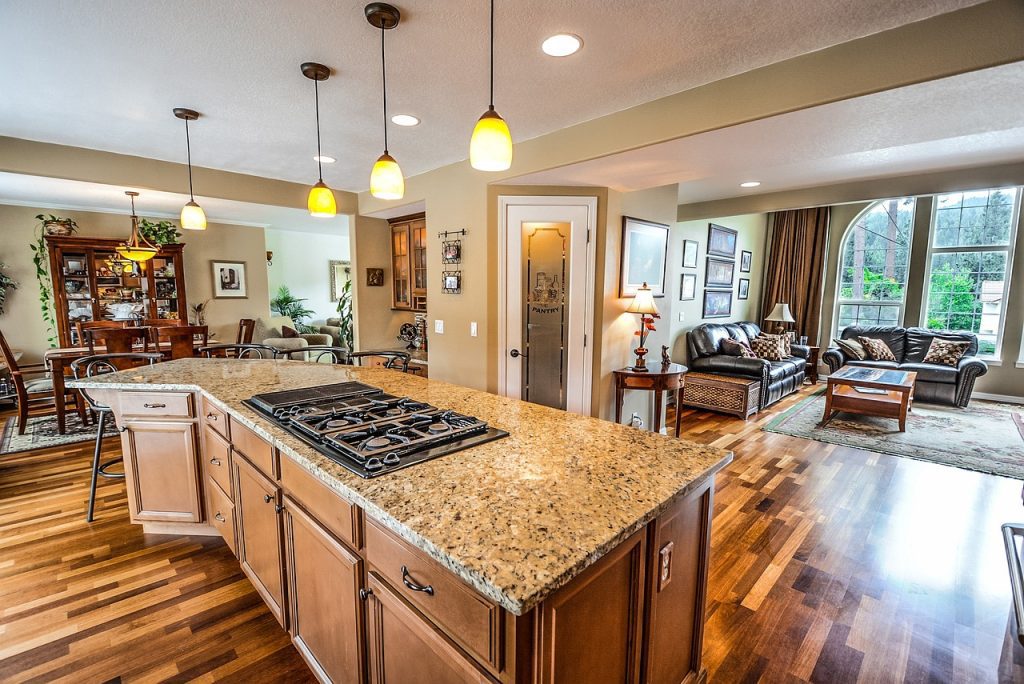 Kitchen granite counter with built-in stovetop and white cabinets