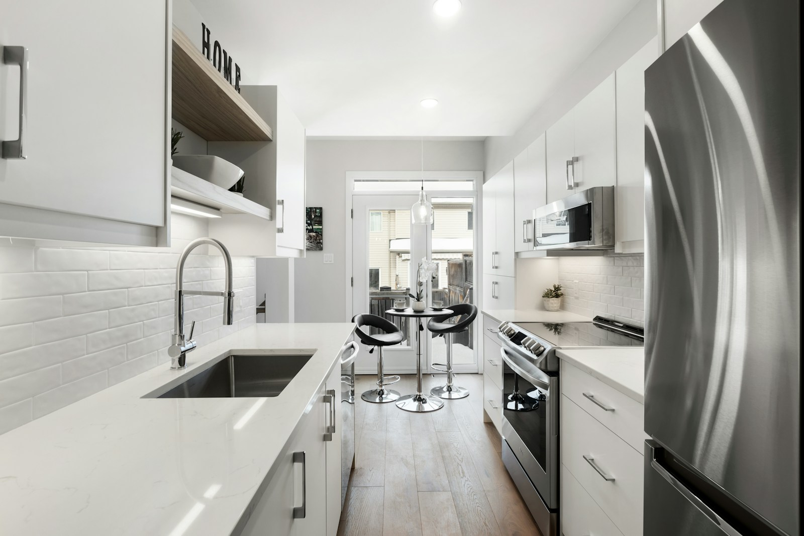 a kitchen with a refrigerator, stove, sink, and stove top oven